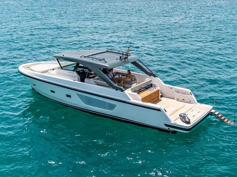 EXPERIENCE Bluegame 54 motor yacht anchored in turquoise water with a seabob on the swim platform.