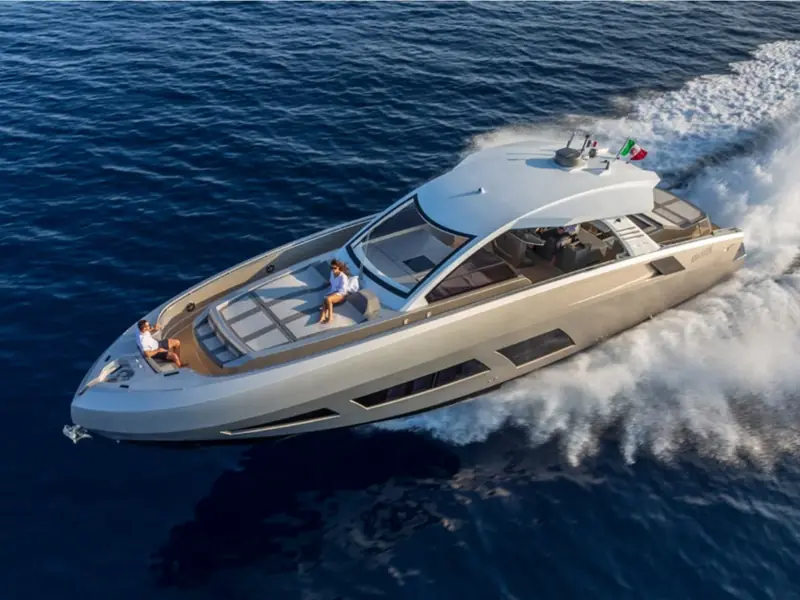 Aerial view of the motor yacht NEXT cruising at speed on the open sea with people on the foredeck.