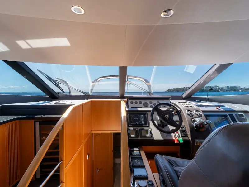 PAPAMARES helm station with steering wheel, navigation displays, and throttle controls overlooking the sea.