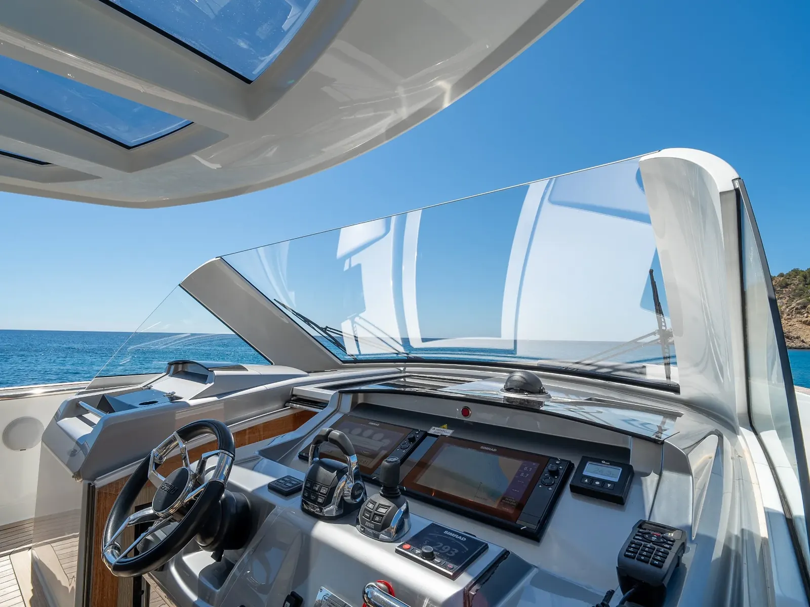 Puesto de mando de PETITCHET con pantallas Simrad, joystick y volante con vistas al mar.