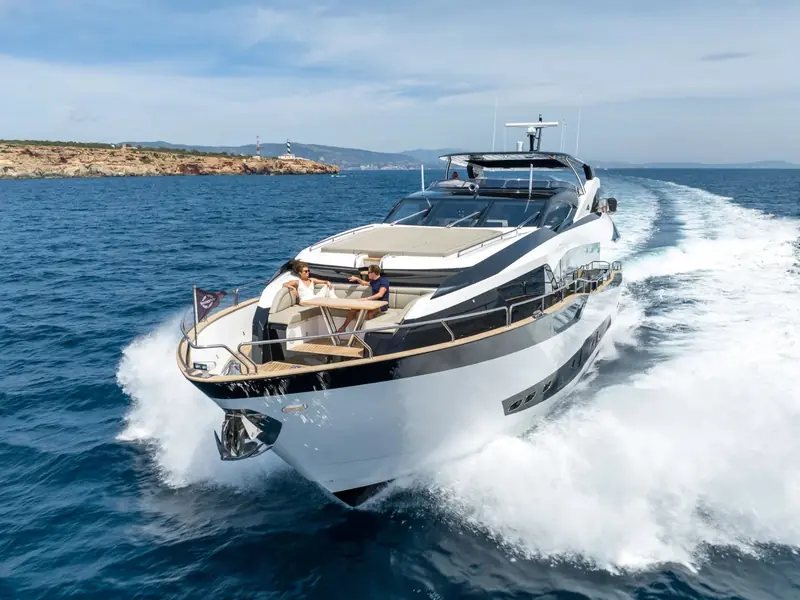 BLUE INFINITY ONE cruising at speed with two people seated on the foredeck lounge area.