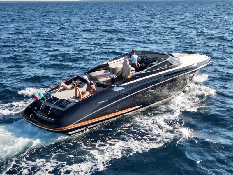 JAD & JULIA Riva 44 Rivarama cruising on the open sea with passengers on the aft sunpad.