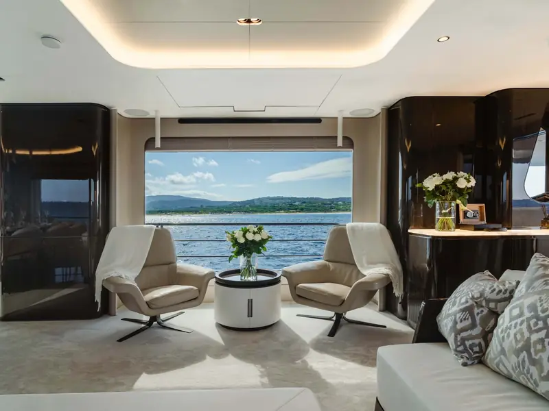 NEMESIS yacht salon interior featuring two leather armchairs facing a large window with a sea view.
