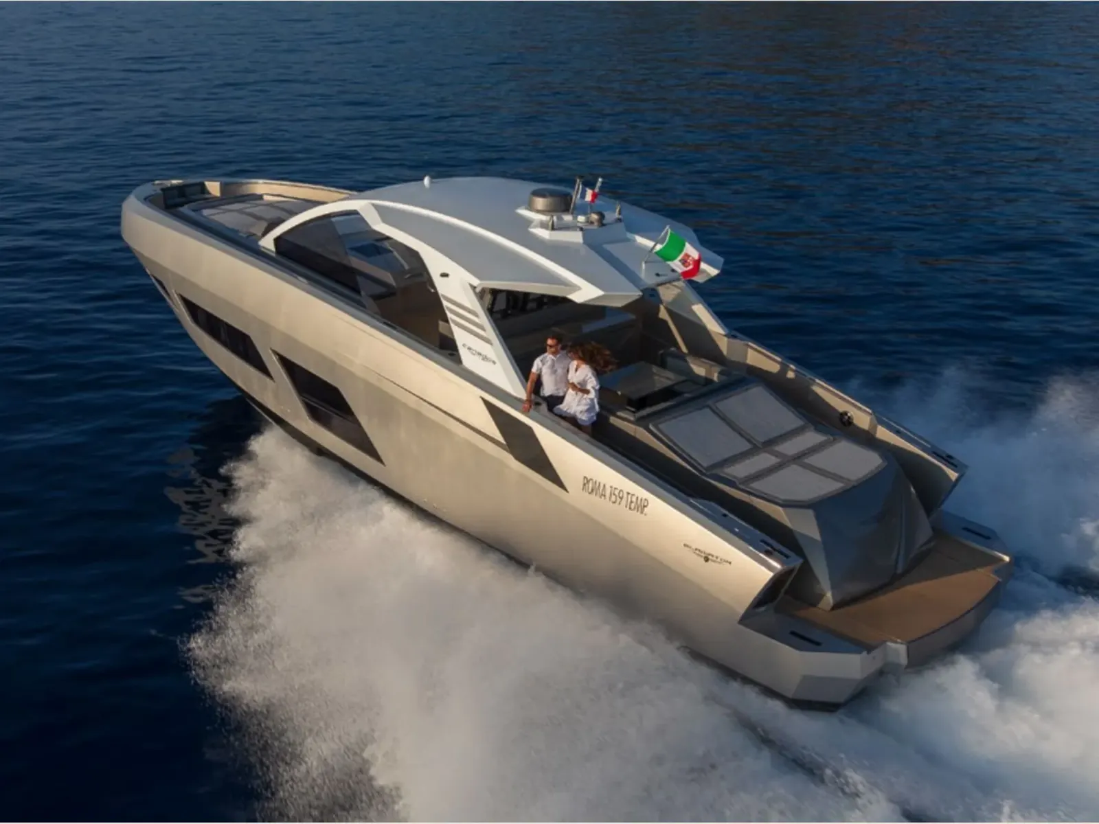 Yacht NEXT cruising on the open sea at high speed with two people visible on deck.