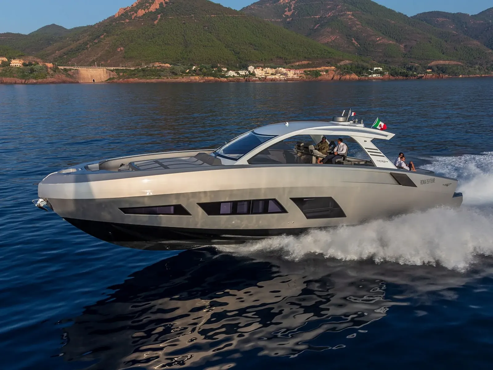 NEXT yacht cruising at speed with mountains in the background.