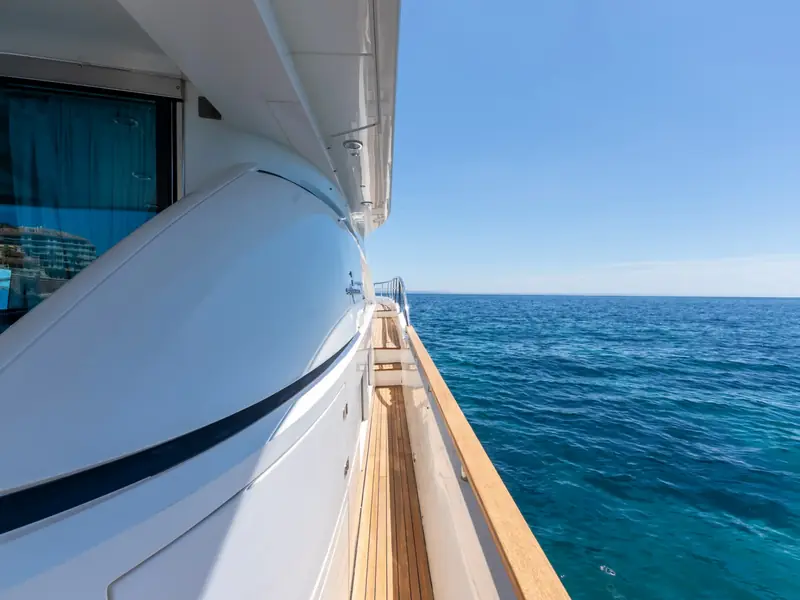 PAPAMARES yacht starboard side deck looking forward with teak flooring and white superstructure against blue water.