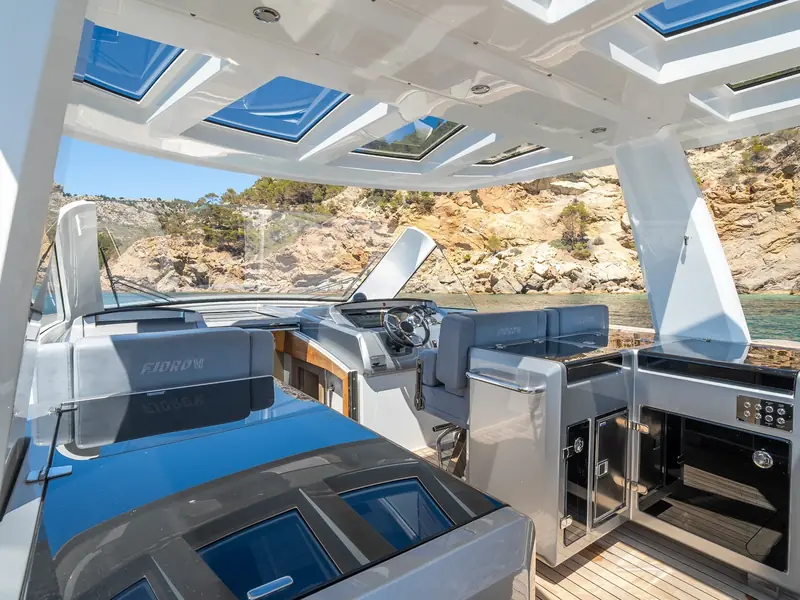 PETITCHET helm station and outdoor galley under a white hardtop with skylights.