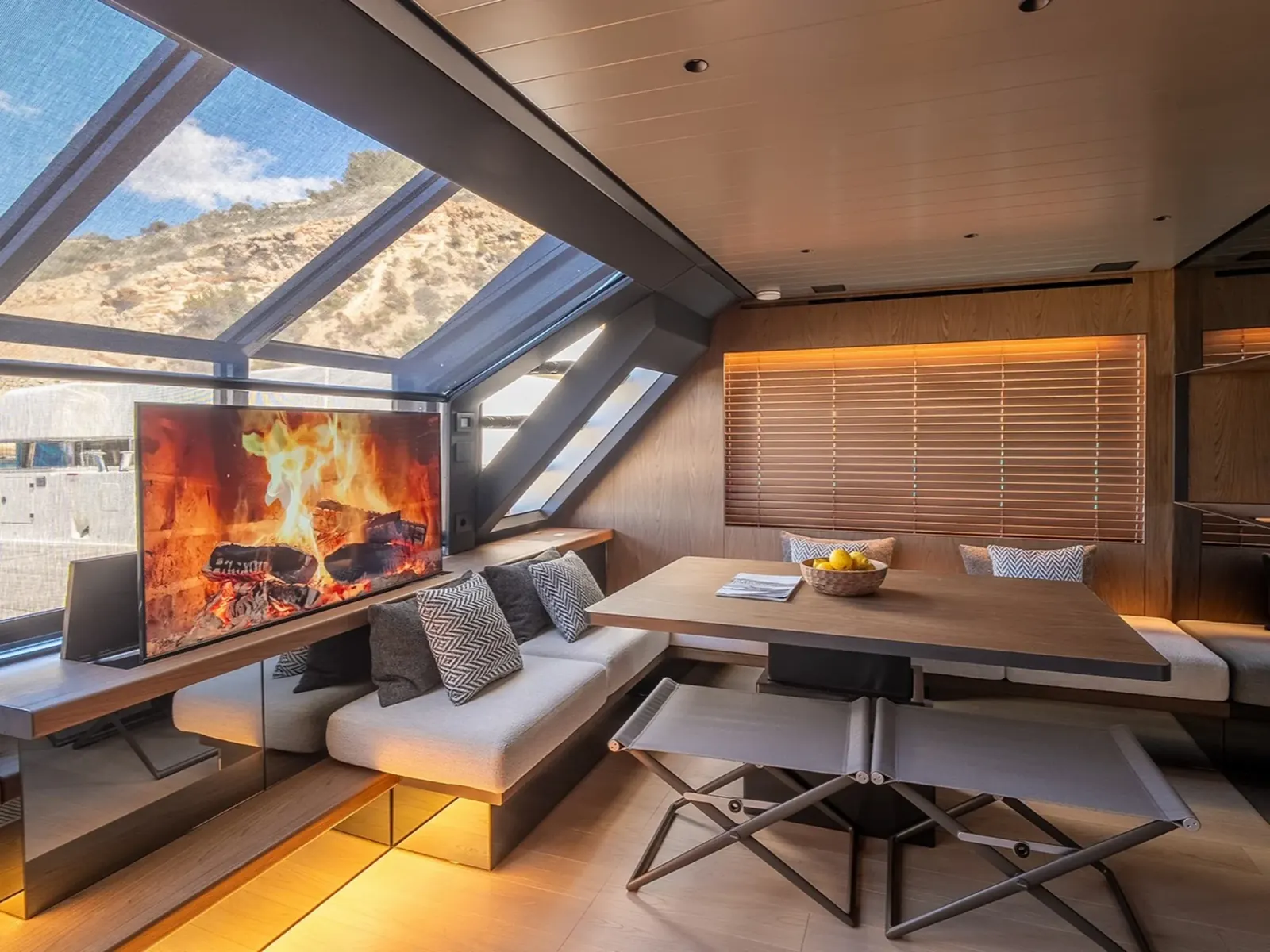 PETITCHET II yacht interior salon with a large television, wooden dining table, and large skylight windows.