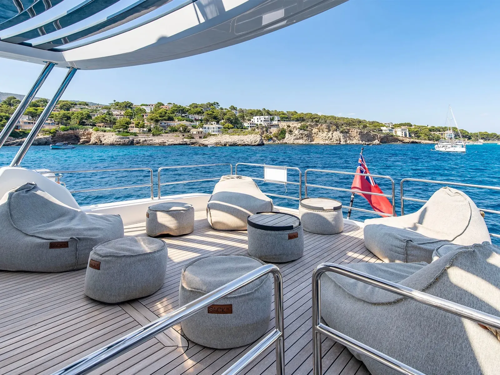 SALACIA yacht flybridge deck with grey bean bag seating and teak flooring overlooking the sea.