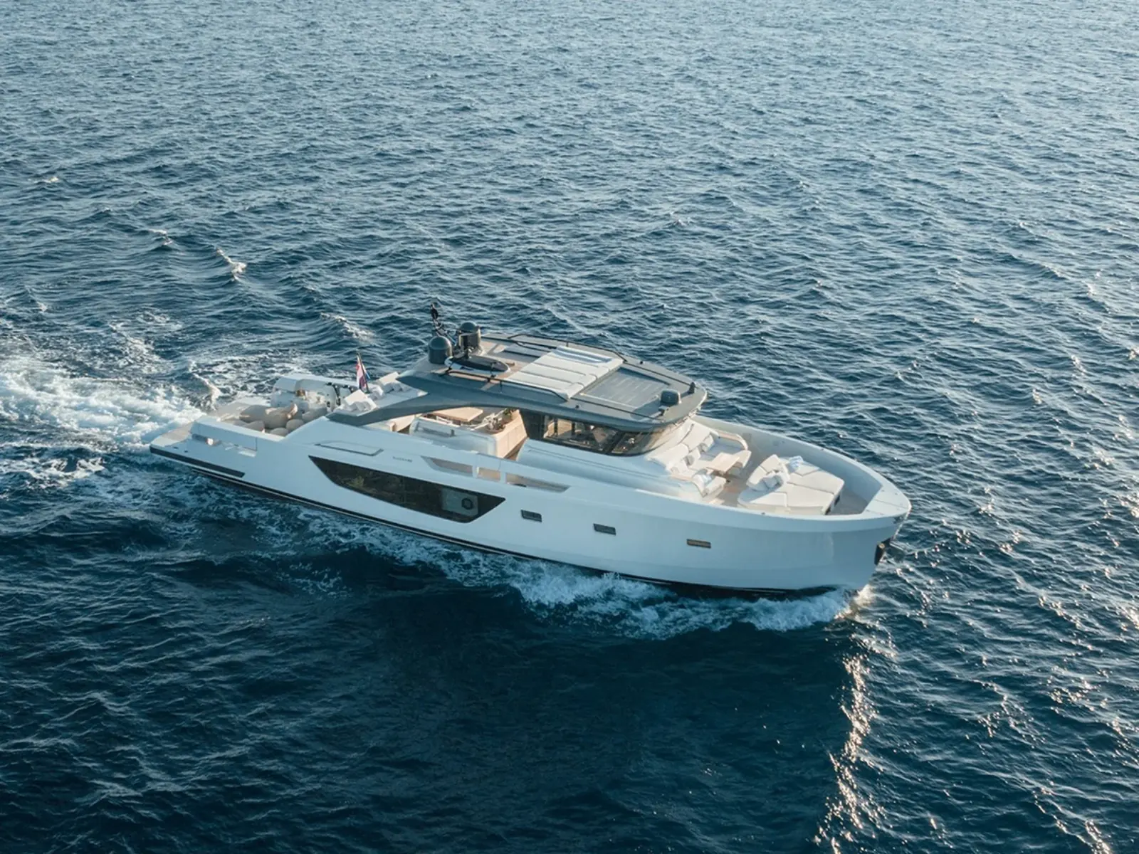 Motoryacht PETITCHET II auf offener See, mit Steuerbordansicht und Sonnenpolstern auf dem Vorschiff.
