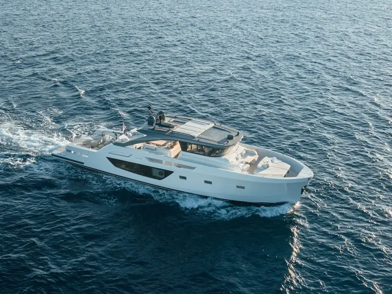 PETITCHET II motor yacht cruising on open water, showing the starboard profile and foredeck sunpads.