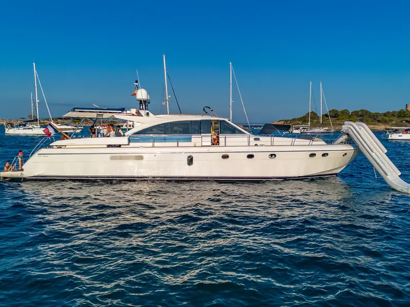 PARODIA yacht profile view at anchor with an inflatable slide deployed from the bow.
