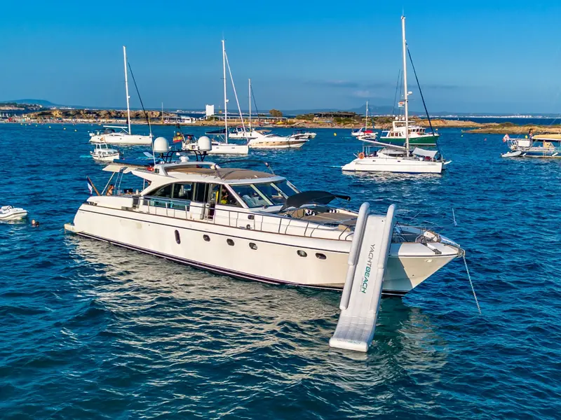 PARODIA yacht anchored with an inflatable slide deployed from the bow in a crowded bay.