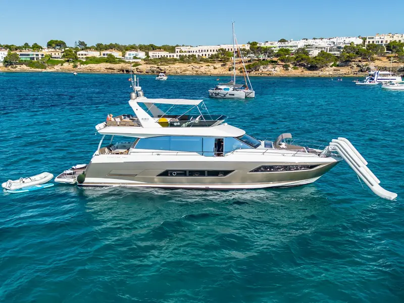 BLUE M yacht anchored with an inflatable slide deployed at the bow and a tender at the stern.