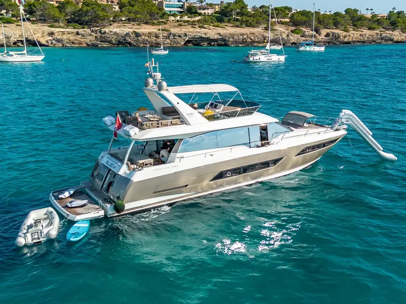 Aerial view of BLUE M, a Prestige 680 motor yacht at anchor with an inflatable slide and tender deployed.