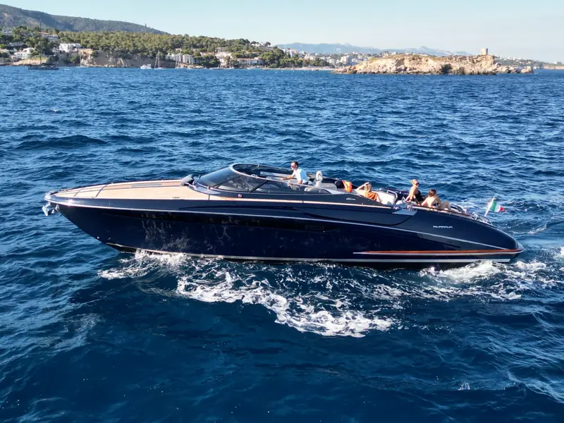 JAD & JULIA, a Riva 44 Rivarama motor yacht with a dark blue hull and teak deck, cruising on the open sea.