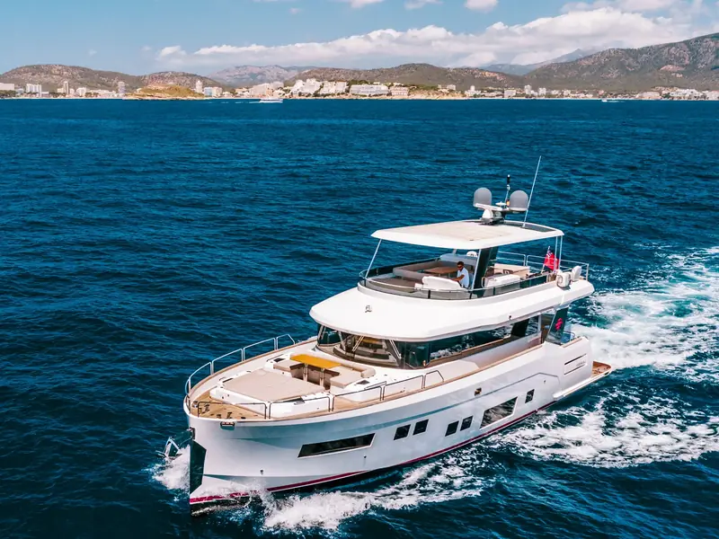 SALACIA motor yacht cruising at sea, showing the flybridge, foredeck seating, and satellite domes.