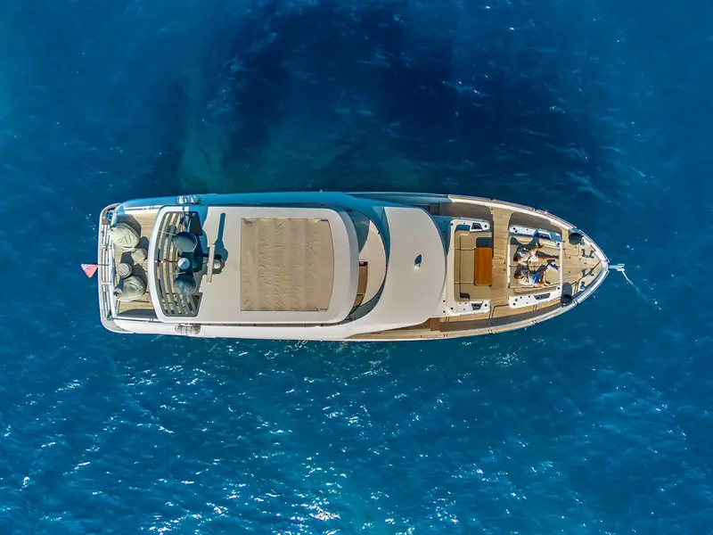 SALACIA motor yacht seen from a directly overhead aerial perspective while anchored in blue water.
